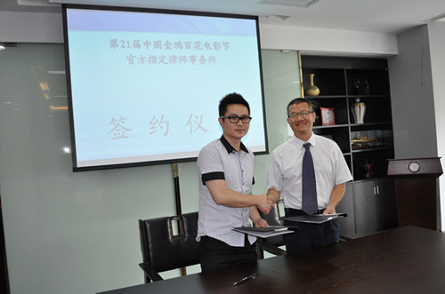 图为胡晨阳律师（右）与周秀强总经理代表双方签约